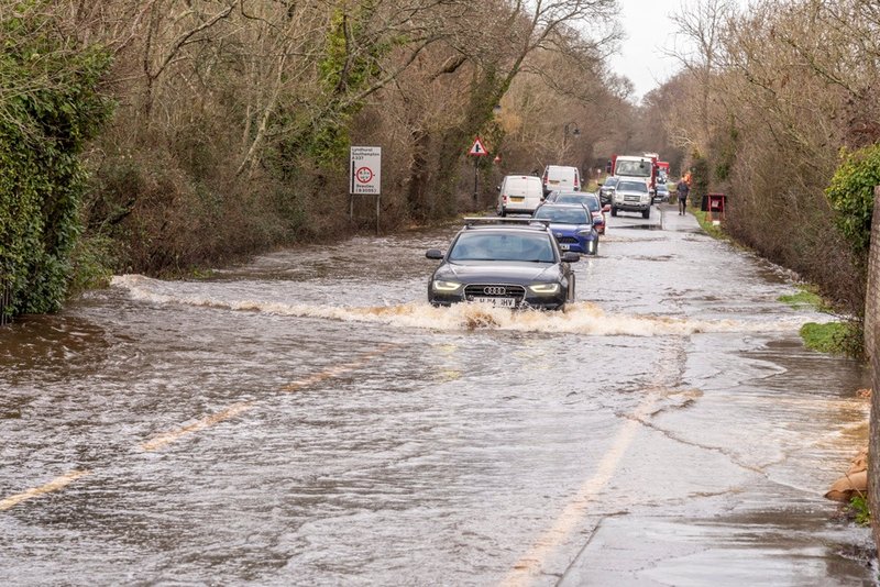 a flooded drive way cause by heavy rains. several roads across the country have been damamged with bridges being blocked as deaths caused by floods rise to more than 80